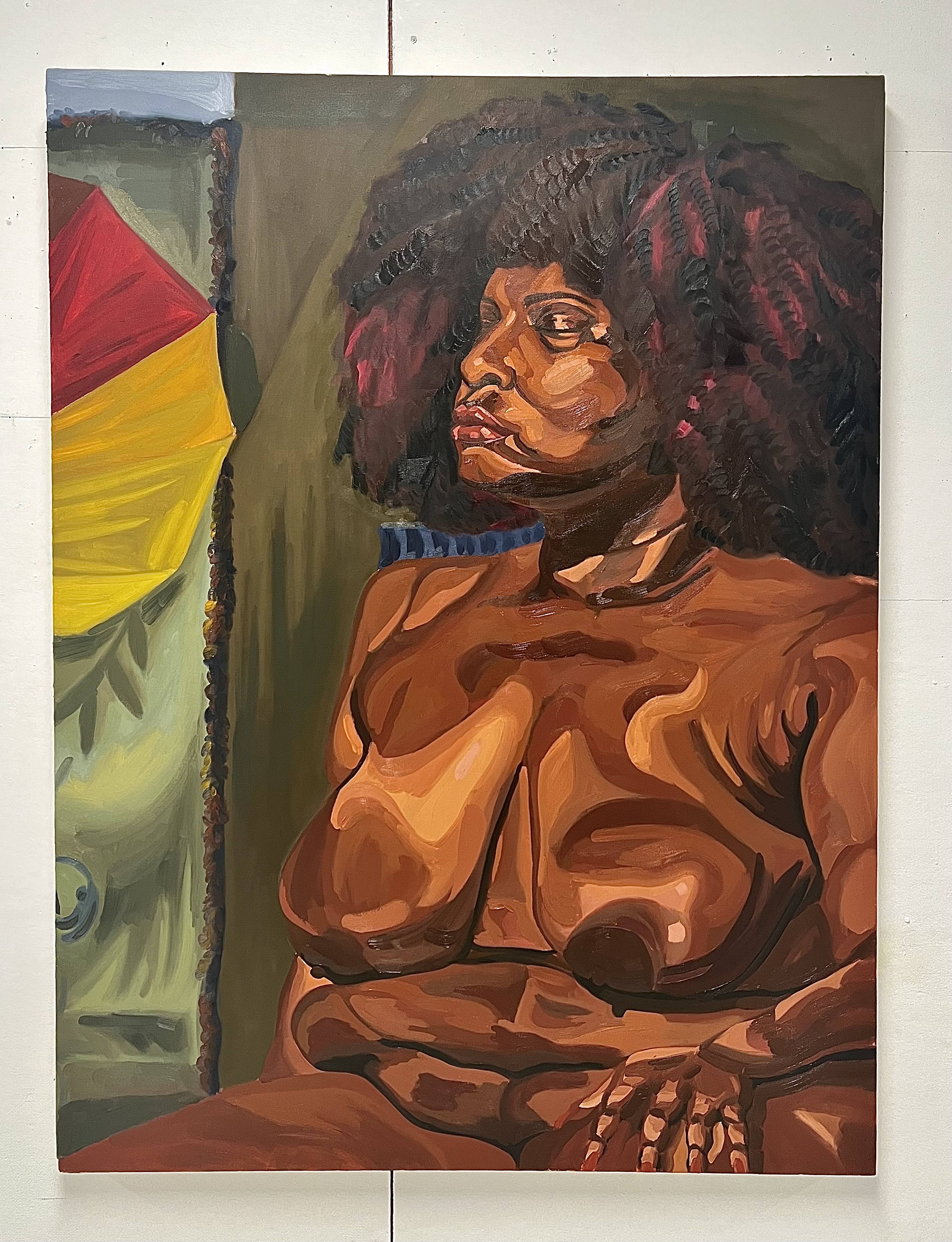 A large oil painting of a topless woman in profile with a full afro, set against an olive background beside a red and yellow shape